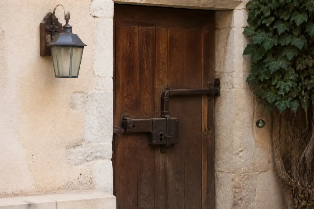 Porte en bois avec serrure massive et lampe murale
