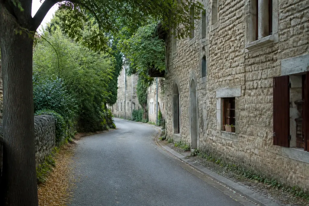 Rue calme bordee de maisons en pierre et arbres